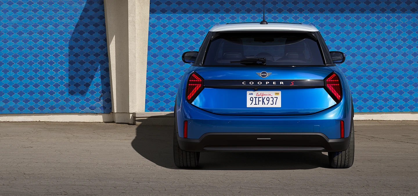 Aizmugures skats uz piecdurvju MINI Cooper Icy Sunshine Blue krāsā ar daudztoņu jumtu Blue krāsā.