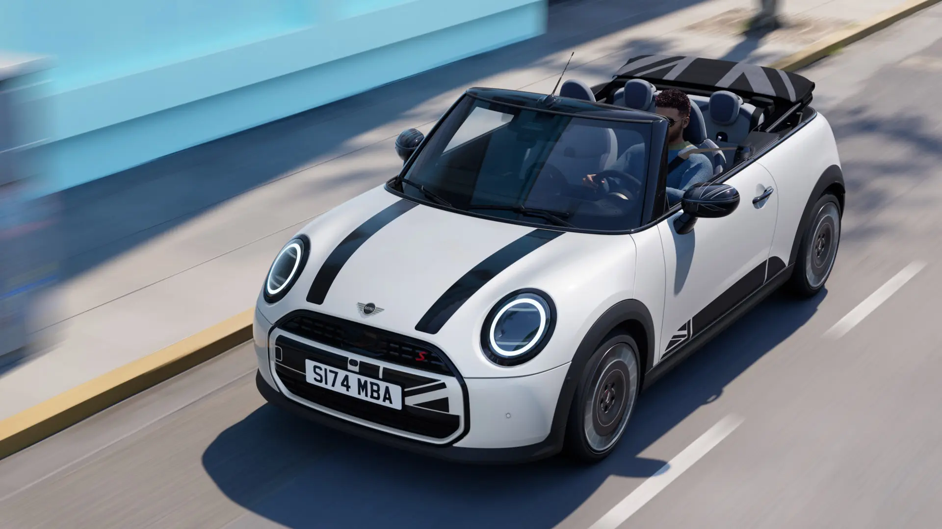 Skats no augšas uz MINI Convertible Nanuq White krāsā ar melnām MINI Heritage dzinēja pārsega uzlīmēm.