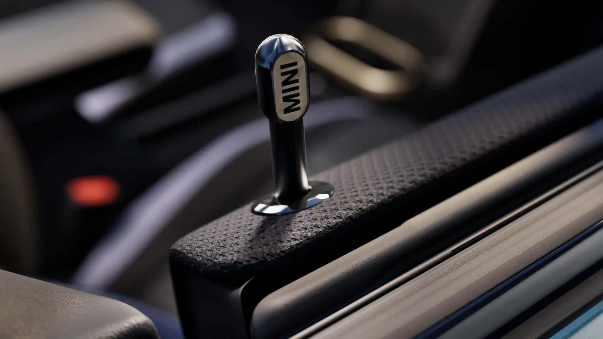 Tuvplāna skats uz oriģinālo MINI melna anodēta alumīnija salona durvju aizslēgšanas pogu.