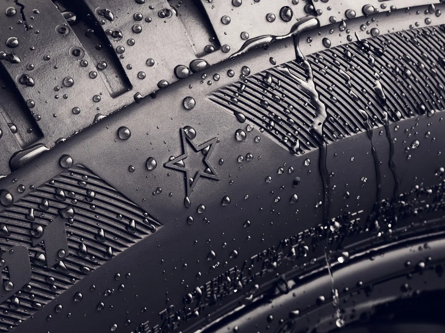 Riepas sānu sienas tuvplāns, kurā redzams zvaigznes simbols, kas norāda uz optimālas veiktspējas apstiprinājumu, izmantojot MINI automobiļos.