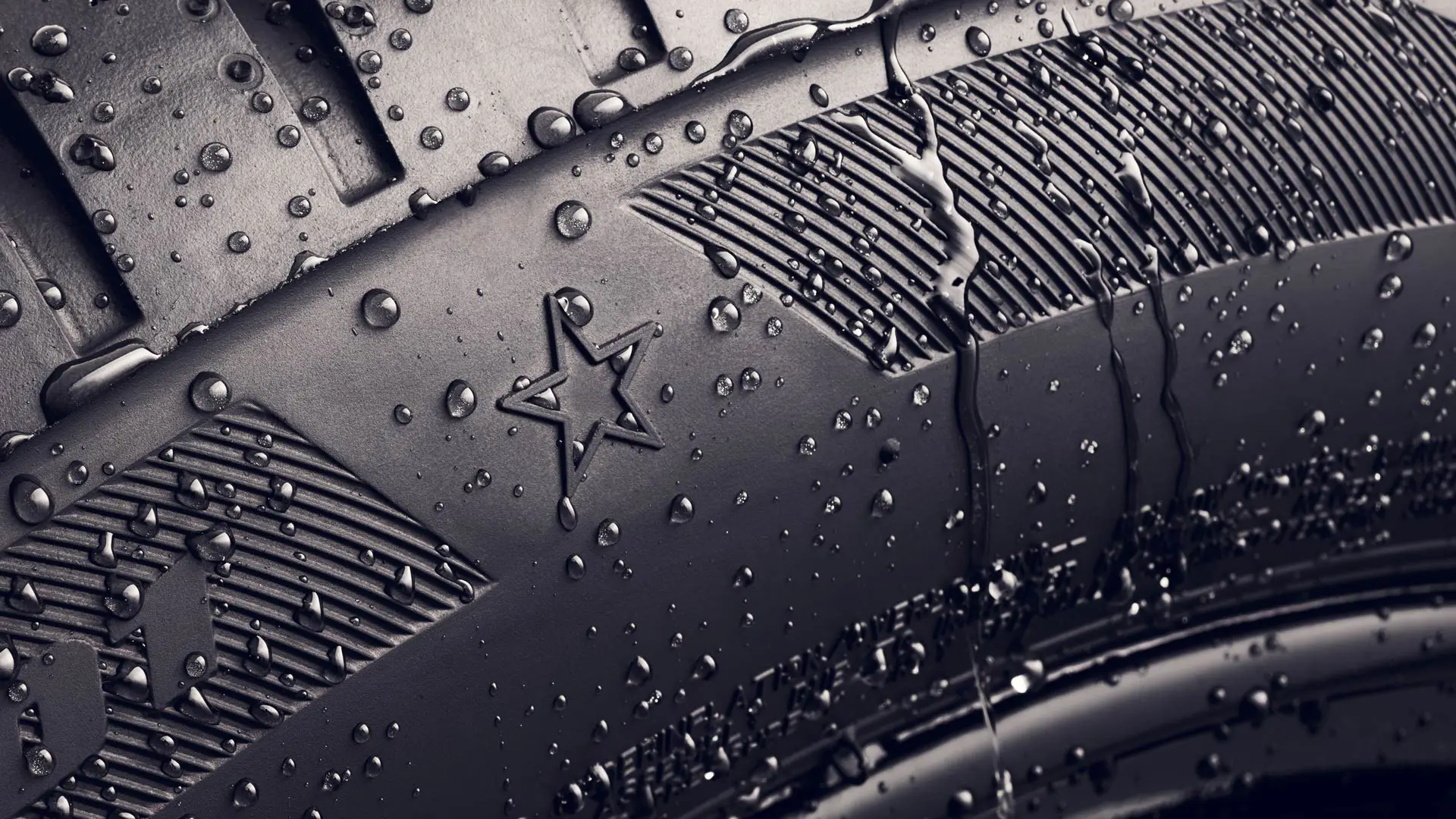 Riepas sānu sienas tuvplāns, kurā redzams zvaigznes simbols, kas norāda uz optimālas veiktspējas apstiprinājumu, izmantojot MINI automobiļos.