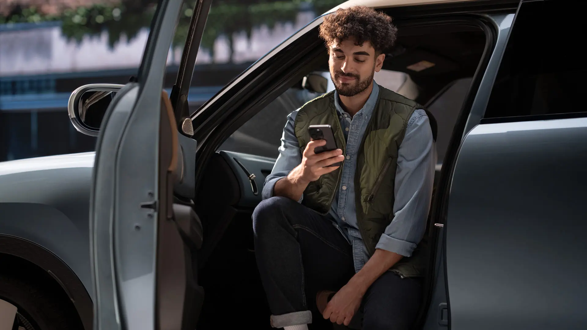 Vīrietis, kas piesaka servisa apmeklējumu, izmantojot savu mobilo tālruni.